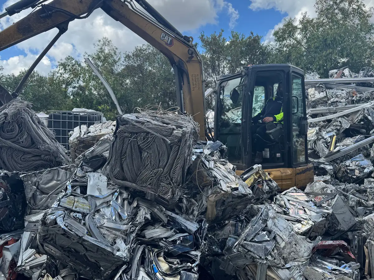 Excavator working a pile of crushed scrap metal at the Ingleburn yard