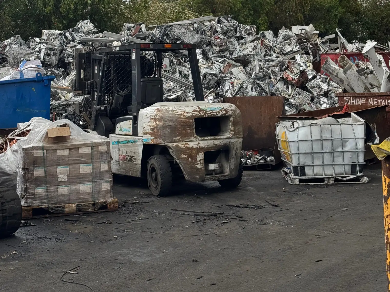 Forklift and stillages in front of the scrap pile at the Ingleburn yard