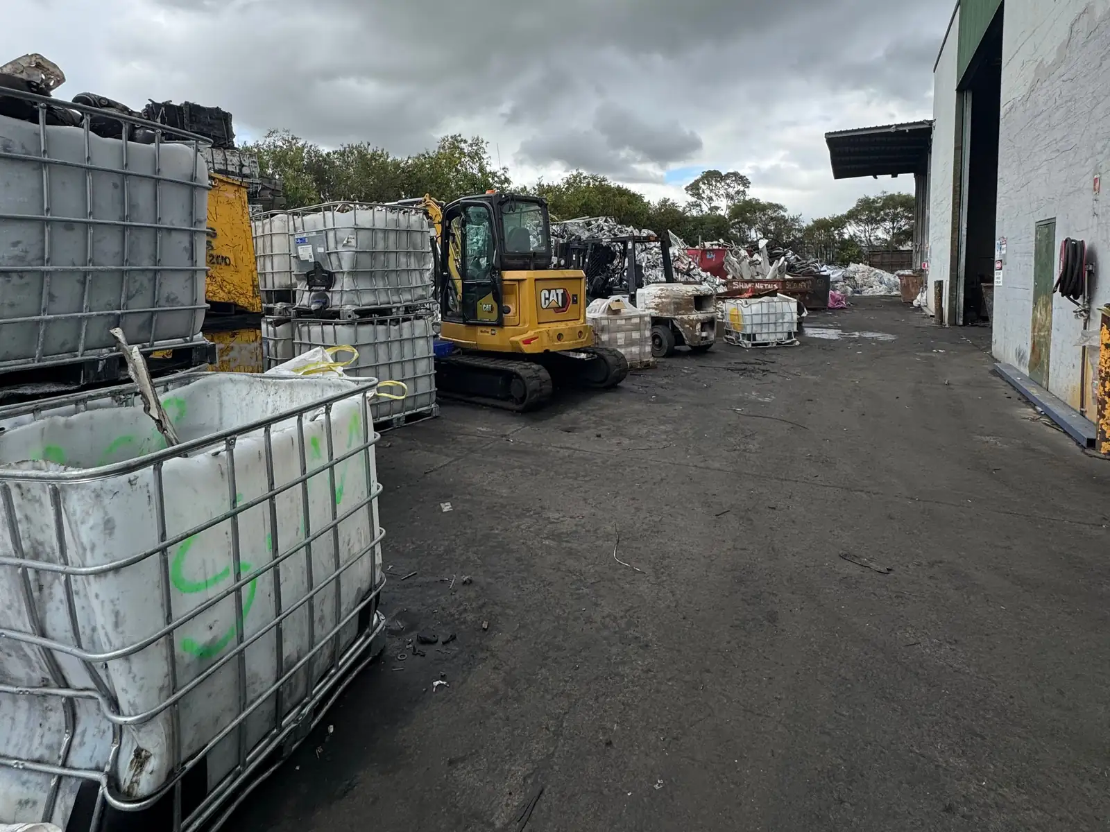 The lane into the Ingleburn yard, lined with stillages, with the excavator at work